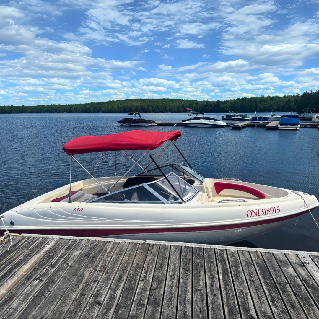 Bowrider boat tied to a dock under sunny skies