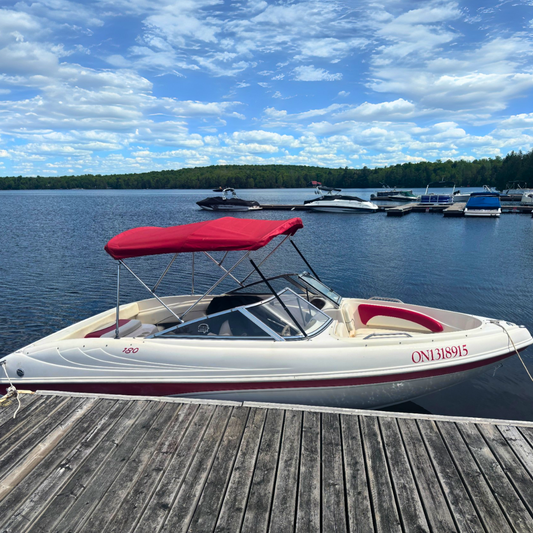 Bowrider boat tied to a dock under sunny skies