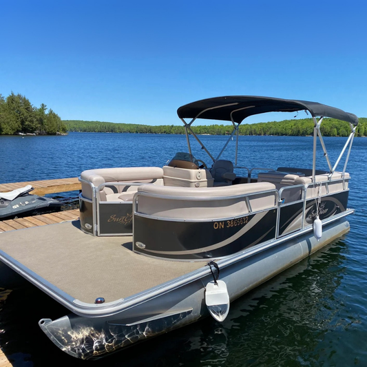 luxury pontoon boat docked in a lake tree lined shore