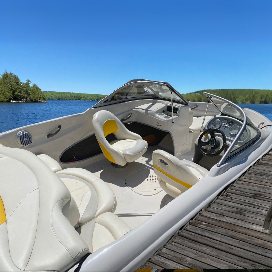 Yellow and white boat docked in a lake with treelined shore